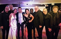 a group of people posing for a photo at a wedding